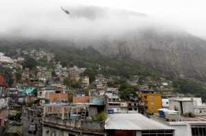 A helicopter circles the steep banks of Rocinha during the Sunday occupation operation, Rio de Janeiro, Brazil
